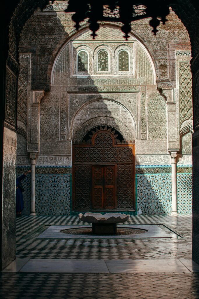 Explore the intricate mosaics and architecture of Al-Attarine Madrasa courtyard in Fes, Morocco.