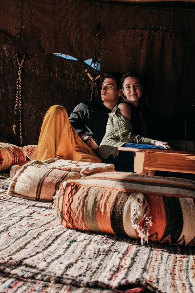 Young couple enjoying leisure time in a cozy Merzouga tent. Cultural and romantic atmosphere.
