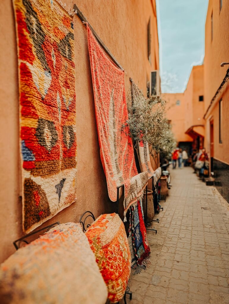 Explore a lively Moroccan alley adorned with vibrant carpets in Marrakesh.