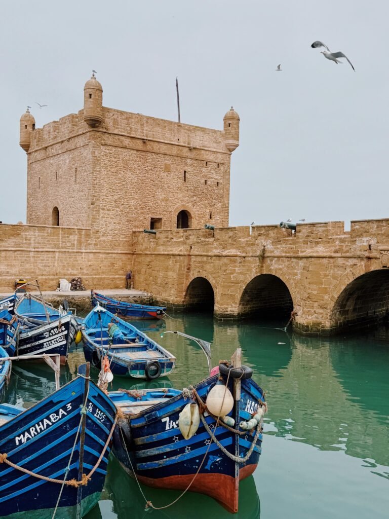 Classic stone fortress overlooking vibrant blue fishing boats in Essaouira