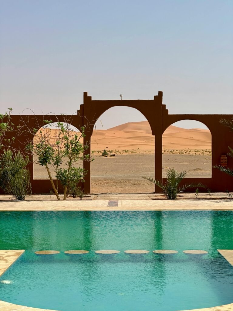 A tranquil pool with a view of the desert through an elegant archway, portraying serenity and escape.