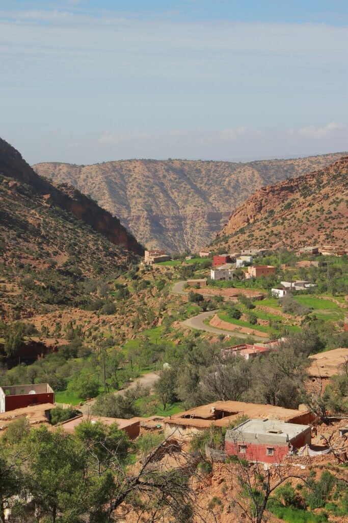 Stunning rural landscape of a mountain valley in Morocco with village homes and lush greenery.