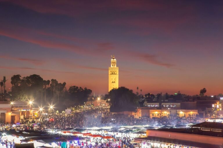 Jemaa el-Fnaa square at night in Marrakech filled with lights, food stalls, street performers, and lively Moroccan atmosphere