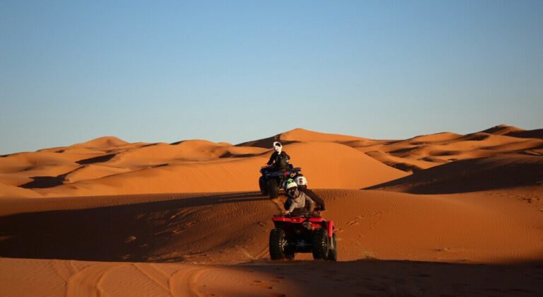 Adventure quad biking across the golden dunes of the Sahara Desert in Merzouga, Morocco, with breathtaking desert landscapes