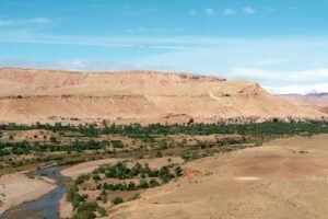 Panorama of a Moroccan desert landscape with a winding river and distant mountains