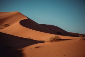 Sand dunes glowing under a sunset sky in Merzouga, Sahara Desert