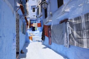 Viajar Sola a Marruecos: Guía Práctica de Seguridad Vivid blue alleyway in Chefchaouen, Morocco, with whitewashed and blue-painted walls