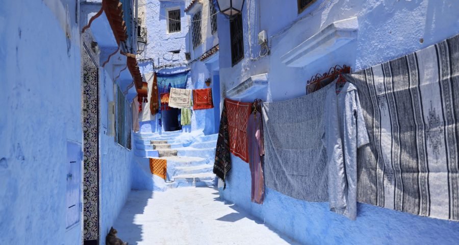 Vivid blue alleyway in Chefchaouen, Morocco, with whitewashed and blue-painted walls