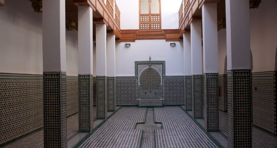 Elegant Moroccan medersa courtyard with intricate mosaic craftsmanship in Fes