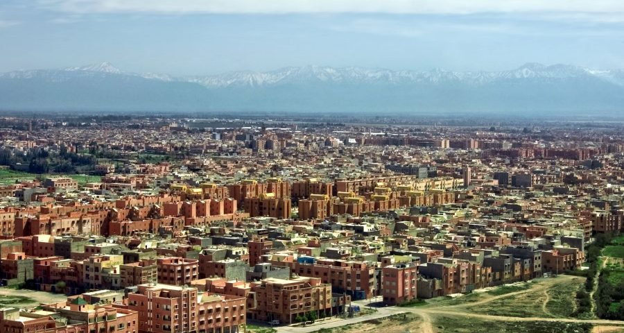 An aerial view of Marrakech with the Atlas Mountains behind it, as seen on arrival