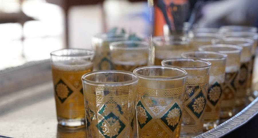 Moroccan mint tea poured from height into ornate glasses