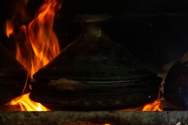 Traditional Moroccan tagine cooking over an open fire, part of the Moroccan food and cooking experience