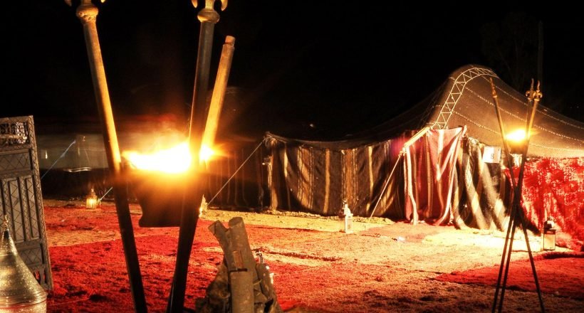 Traditional nomadic Berber tent at night in Morocco, lit by torchlight