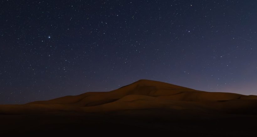 Starlit Sahara Desert dunes at night in Morocco